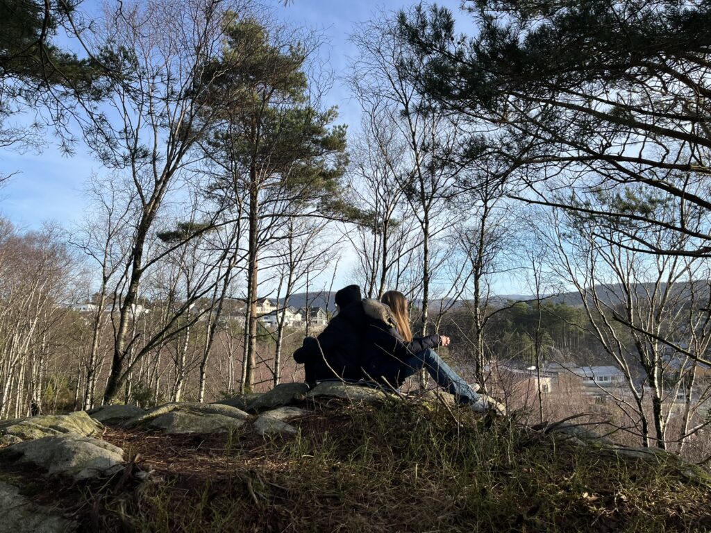 Learners sitting back to back in nature, during a deep listening exercise. Photo: Marte Maurabakken/Climate Creativity.