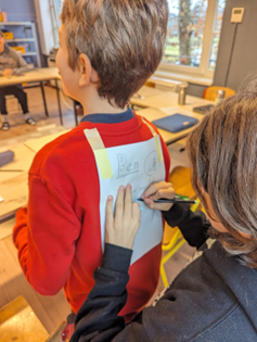 Learners are turning each other into superheroes by writing strengths on one another’s capes. Photo by Carmelo Zamora at REAL School Budapest.