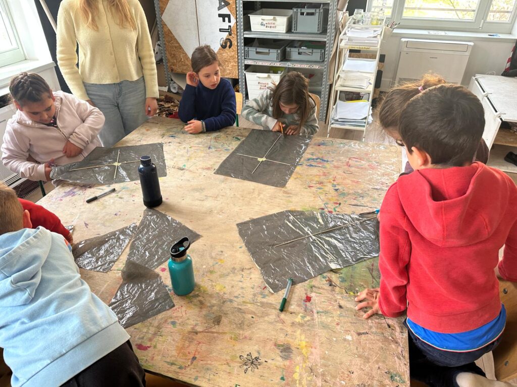 In the making! Learners using recycled plastic and wooden sticks to create their kites. Photo by Sierra de Lew, REAL School Budapest